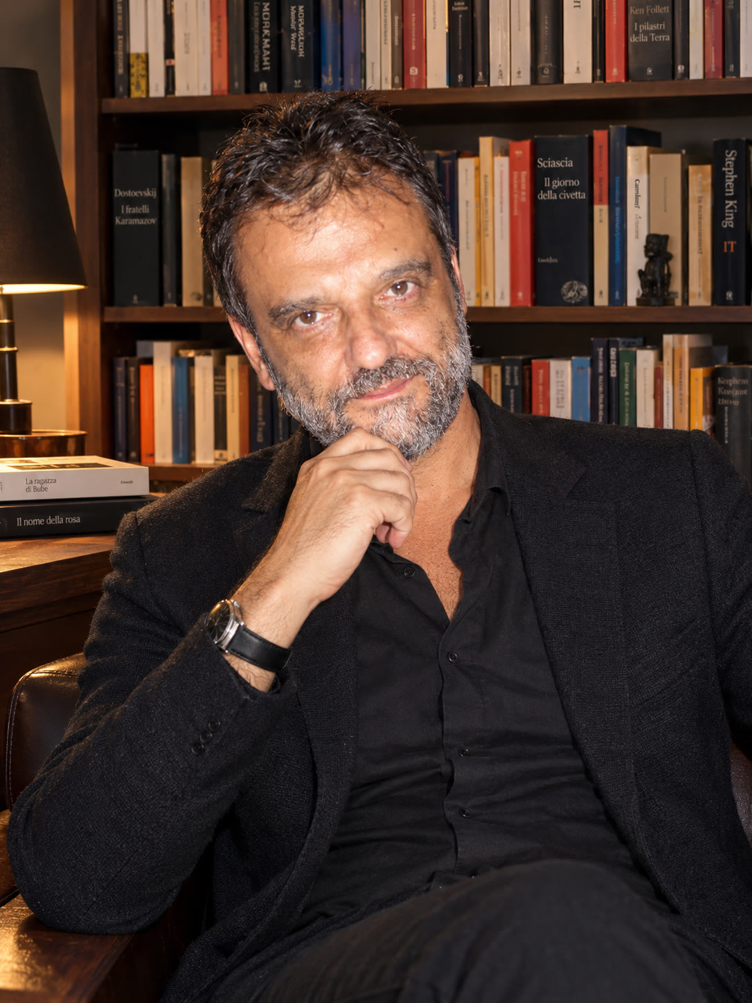 Nicolmario Ciccotti seduto davanti a una libreria